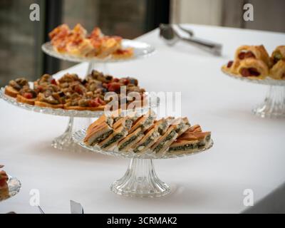Elegante assortimento di stuzzichini esposti sugli stand di cristallo di una Villa Italiana Patio buffet Party Event Gathering Foto Stock