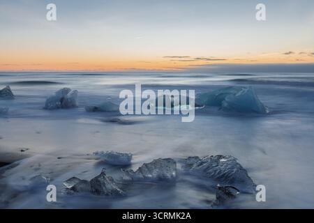 Diamond Beach, Fellsfjara, di Jökulsárlón: Ghiaccio scintillante su sabbia nera con surf Atlantico nel Parco Nazionale di Vatnajökull, Islanda meridionale Foto Stock