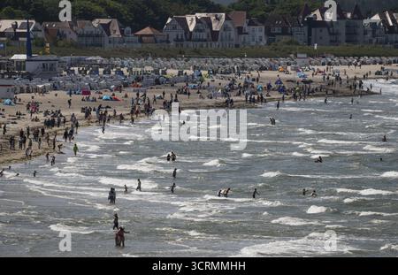 Turisti in spiaggia e in mare, onde, sdraio sullo sfondo, Warnemuende, Rostock, Meclemburgo-Vorpommern, Germania Foto Stock