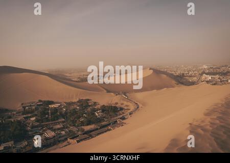 Vista aerea della città desertica e delle dune che circondano l'oasi di Huacachina, Ica, Perù. Foto Stock
