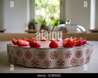 Crostata di fragole fatta in casa con fragole fresche in un piatto di ceramica vintage su un tavolo rustico in legno. Foto Stock