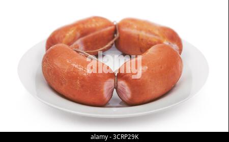 salsicce affumicate di frankfurter su un piatto bianco, isolate Foto Stock