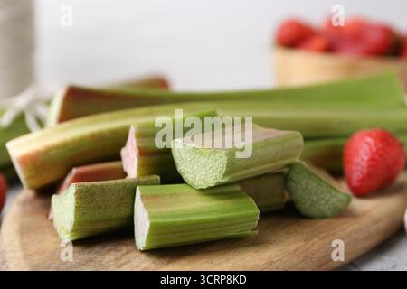 Tagliare il rabarbaro fresco e le fragole sul tavolo, primo piano Foto Stock