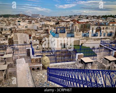Vista sul tetto dal Panorama Café nella vecchia Medina di Tunisi, Tunisia: Ringhiere blu, posti a sedere in terrazza e paesaggio urbano. Catturato il 22 settembre 2025. Foto Stock