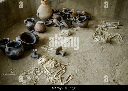 Sito archeologico di sepoltura che mostra resti scheletrici umani accanto a vasi in ceramica e manufatti dell'antica città di Gabala, l'ex capitale Foto Stock