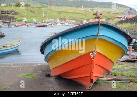 Barca da pesca sulla costa di Hanga Roa, Isola di Pasqua, con sfondo verde Foto Stock