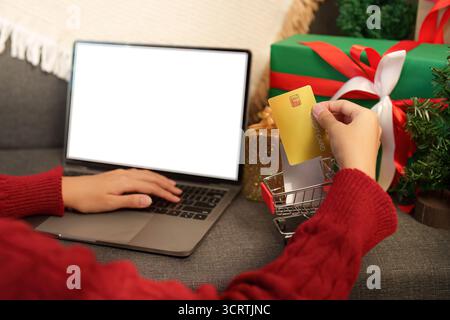 Shopping di Natale. Aggiunta di una carta di credito al carrello online. Foto Stock