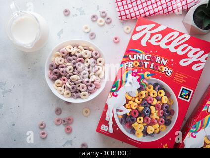 LONDRA, Regno Unito - 28 MAGGIO 2025: Kellogg's Froot Loops, cereali per la colazione in un piatto con cucchiaio e vasetto del latte sul tavolo da cucina. Foto Stock
