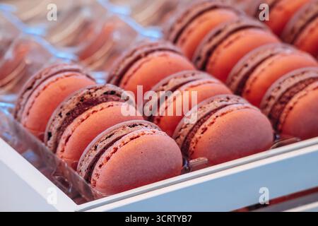 Macaron colorati assortiti disposti in file presso una pasticceria francese Foto Stock