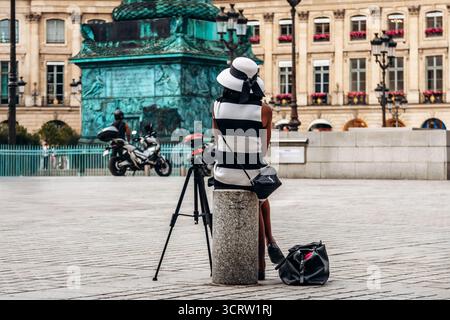 Parigi, Francia - 7 settembre 2025: Modella che riposa durante un servizio fotografico su Place Vendôme Foto Stock