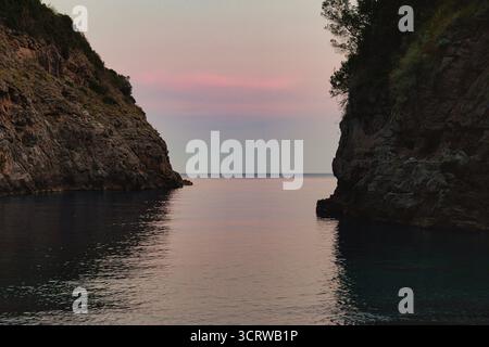 Tramonto maestoso sulla Ocean Bay incorniciata da scogliere Foto Stock