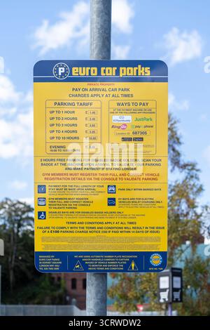 Vista ravvicinata di un cartello giallo e blu per il pagamento dei parcheggi in euro che mostra la tariffa del parcheggio e le modalità di pagamento. Foto Stock