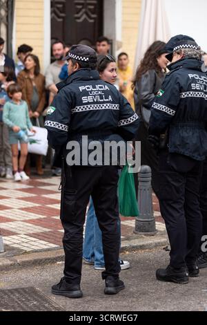 Agenti di polizia municipali in servizio e interagendo con i cittadini durante le celebrazioni della settimana Santa a Siviglia, Spagna. Foto Stock