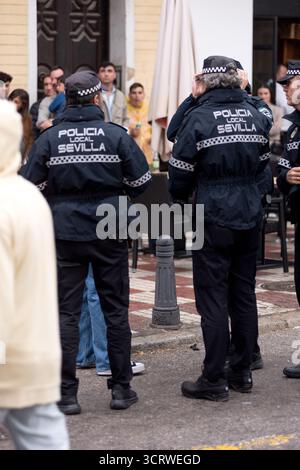 Agenti di polizia municipali in servizio e interagendo con i cittadini durante le celebrazioni della settimana Santa a Siviglia, Spagna. Foto Stock