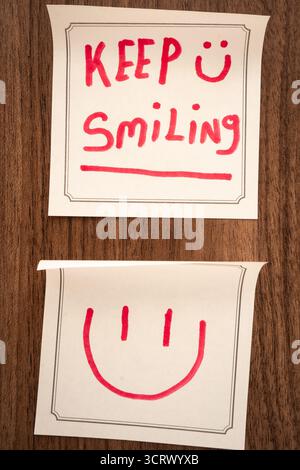 Note adesive con un messaggio positivo, su sfondo di legno. Sfondo creativo. Foto Stock