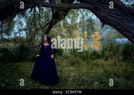 Donna con un lungo vestito nero per Halloween, la sposa di Dracula, vampiri, strega moderna Foto Stock