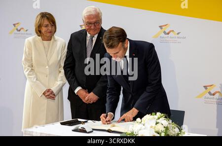 3 ottobre 2025, Saarland, Saarbrücken: Il presidente francese Emmanuel Macron firma il libro d'oro della città di Saarbrücken, accanto a lui ci sono il presidente tedesco Frank-Walter Steinmeier e sua moglie Elke Büdenbender. Il 3 ottobre 2025, la Germania celebra il 35° anniversario della riunificazione tedesca. Foto: Pinter Laszlo/dpa Foto Stock