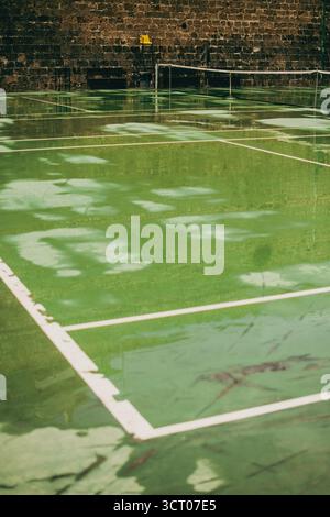 Un tranquillo campo da tennis a Heraklion, in Grecia, catturato senza giocatori o distrazioni. La scena enfatizza le linee pulite, lo spazio aperto e la geometria di Foto Stock
