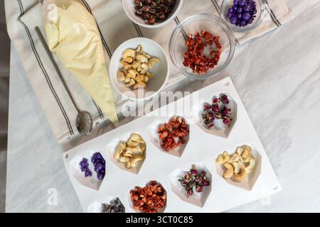 Stampo a forma di cuore al cioccolato con noci, frutta secca e decorazioni Foto Stock