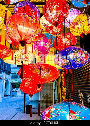 Lanterne colorate con motivi floreali appese in fila in un mercato di strada durante una festa notturna a ipoh malesia Foto Stock