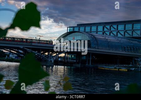 Stazione centrale di Berlino (Hauptbahnhof) con treno S-Bahn a Dusk sul fiume Sprea, Germania. Foto Stock