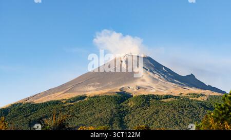 Una montagna con una nuvola di fumo che sale da essa. vulcano popocatepetl messico, Foto Stock