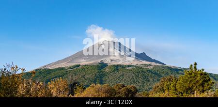 Una montagna con una nuvola di fumo che sale da essa. vulcano popocatepetl messico, Foto Stock