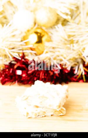 Blocchi di Turron con mandorle e nocciole su tagliere, su un tavolo di legno. Foto Stock
