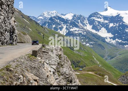 Vista della strada alpina scavata nella scarpata rocciosa delle alte Alpi vicino alla cima del passo asfaltato più alto passabile alto 2764 2770 metri col de Foto Stock
