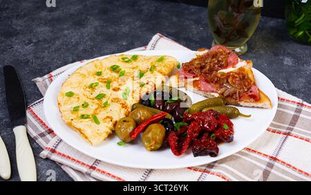Omelette con pane tostato, olive e pomodori secchi. Gustosa colazione con omelette Foto Stock