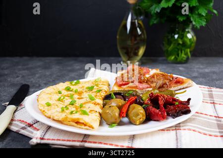 Omelette con pane tostato, olive e pomodori secchi. Gustosa colazione con omelette Foto Stock