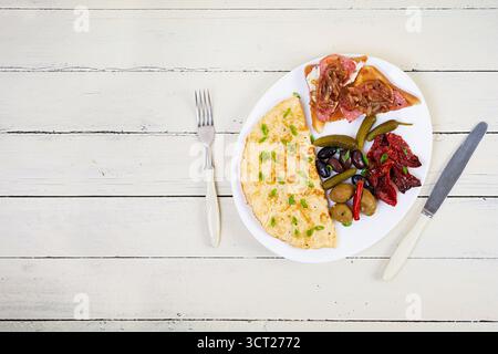 Omelette con pane tostato, olive e pomodori secchi. Gustosa colazione con omelette Foto Stock