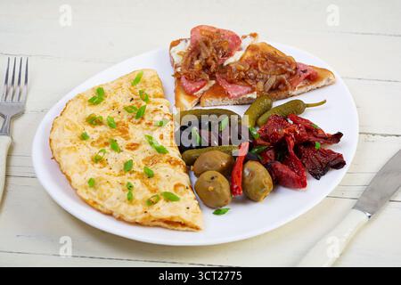 Omelette con pane tostato, olive e pomodori secchi. Gustosa colazione con omelette Foto Stock