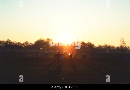Regno Unito. Inghilterra. Londra. Clapham Common. Partita di football maschile al tramonto. Foto Stock