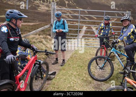 Un gruppo di mountain bike senior nel Glen Gairn Cairngorms National Park in Scozia Foto Stock
