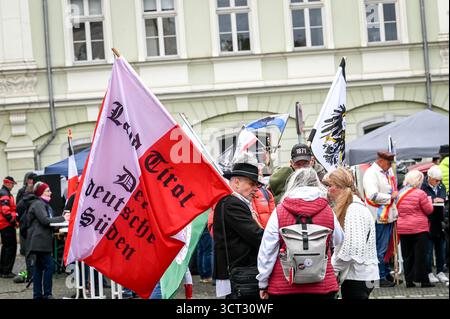 Weimar, Germania. 4 ottobre 2025. I partecipanti provenienti dal Tirolo partecipano a un incontro nazionale della cosiddetta scena Reichsbürger con la loro bandiera sulla Platz der Demokratie a Weimar. Poi marciano attraverso il centro della città. Crediti: Heiko Rebsch/dpa/Alamy Live News Foto Stock