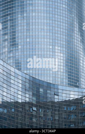 Una facciata di vetro di un edificio in un quartiere finanziario Foto Stock