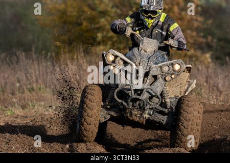 Un quad pieno di fango durante una gara enduro Foto Stock