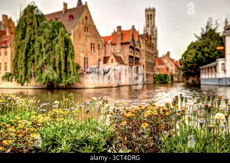 L'iconico canale Rozenhoedkaai di Bruges fiancheggiato da edifici storici fiamminghi e dal campanile di Bruges che si riflette nelle acque calme Foto Stock