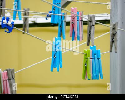 Clothespins colorati appesi su Clothesline all'aperto Foto Stock