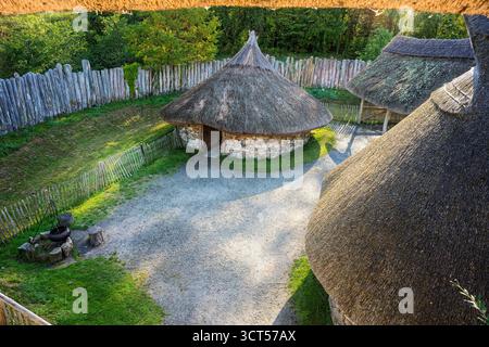 Ricostruita roundhouse della tarda età del bronzo/del primo ferro all'interno del recinto della palizzata a ringfort presso l'Irish National Heritage Park, Irlanda. Foto Stock