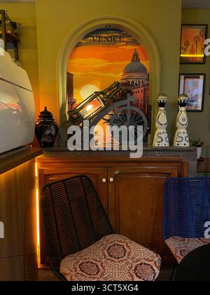 Interno del caffè a tema vintage a Tangeri con un murale di Venezia e statuette decorative. Catturato il 3 ottobre 2025. Foto Stock