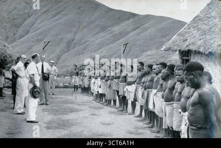 Fotografia di vintage 1960 dei prigionieri di Kukukuku, che scontano condanne principalmente per omicidio al posto di pattuglia di Menyamya. Il distretto di Menyamya è un distretto della provincia di Morobe della Papua nuova Guinea.1964. Gli uomini Kukukuku, noti anche come popolo Angu o Änga, furono ancora oggetto di razzie e combattimenti nel 1964, quando fu scattata questa foto. Foto Stock