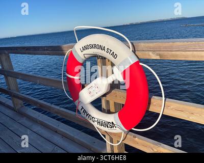 Anelli salvagente di emergenza su cavalletti posizionati accanto all'acqua in Svezia e Danimarca, compresi dispositivi galleggianti arancioni con linee collegate per il lancio Foto Stock