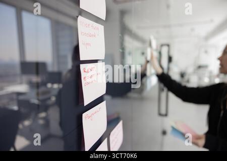 Primo piano di appunti di carta adesivi sul pannello di vetro per addestramento Foto Stock