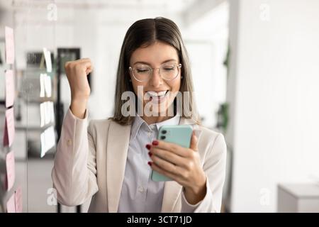 Felice donna latina professionista di successo che usa lo smartphone Foto Stock