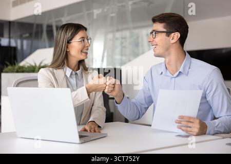 Un paio di allegri colleghi di lavoro latini che danno il pugno Foto Stock
