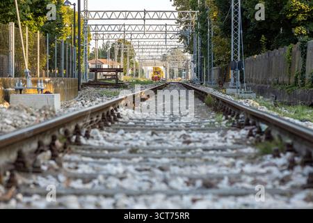 Binari ferroviari in manutenzione sulla linea Adria-Mestre con treno giallo di manutenzione alla stazione di piove di sacco, Padova, Veneto, Italia Foto Stock