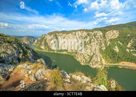 Il possente Danubio si snoda attraverso i Carpazi, formando una suggestiva gola e una frontiera naturale tra Serbia e Romania, incorniciata da lussureggianti boschi e. Foto Stock