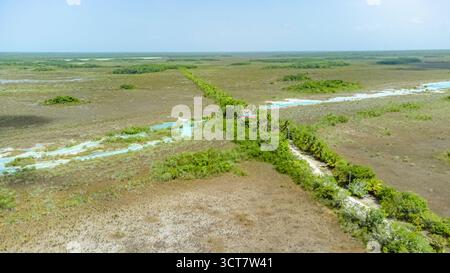 Bacalar, Messico, Quintana Roo, grande campo aperto con un fiume che lo attraversa. Il fiume è blu e l'erba è verde Foto Stock